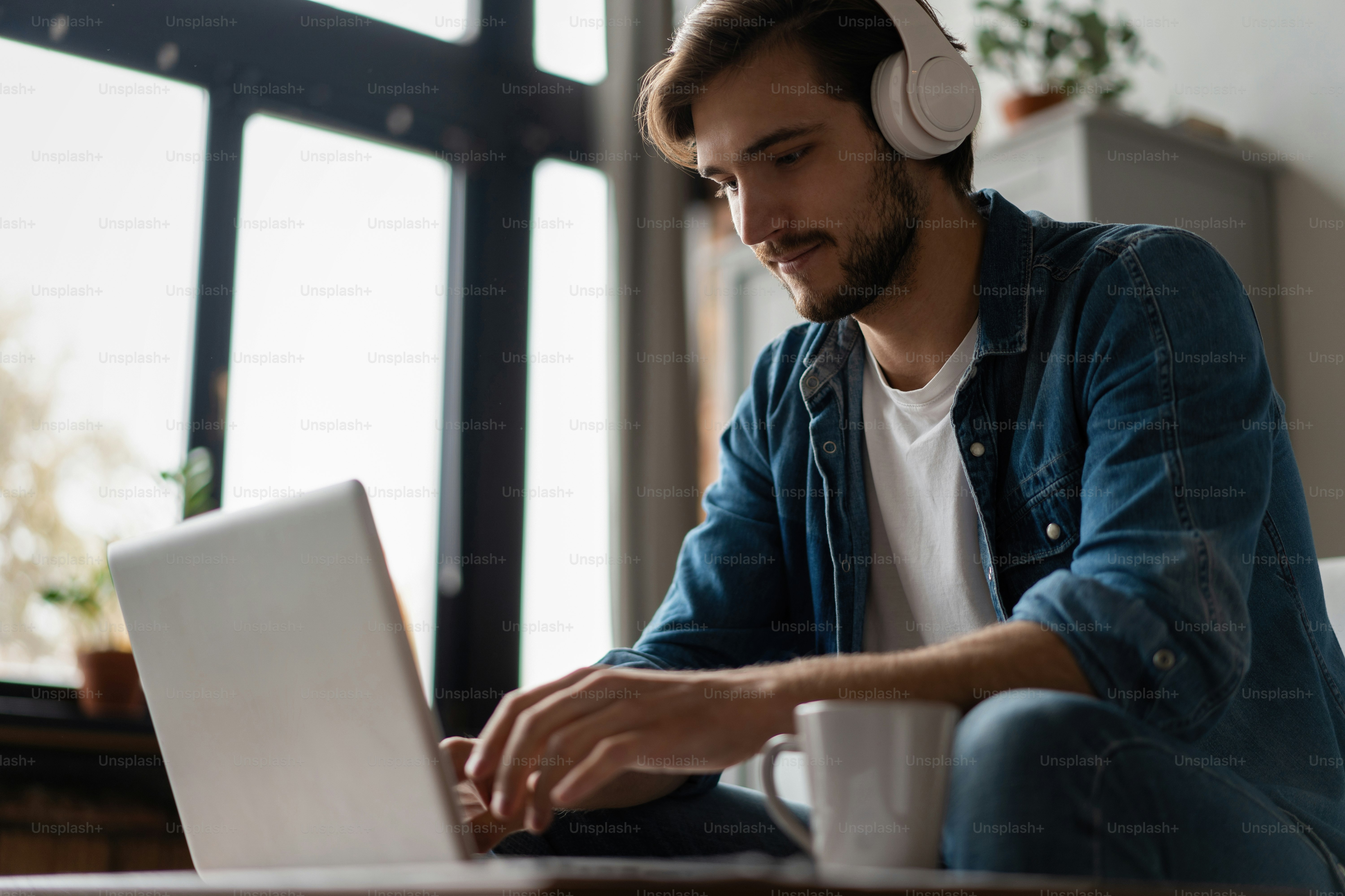 Pria Menggunakan Laptop Memakai Headphone Bersantai Duduk Di Sofa Di Rumah