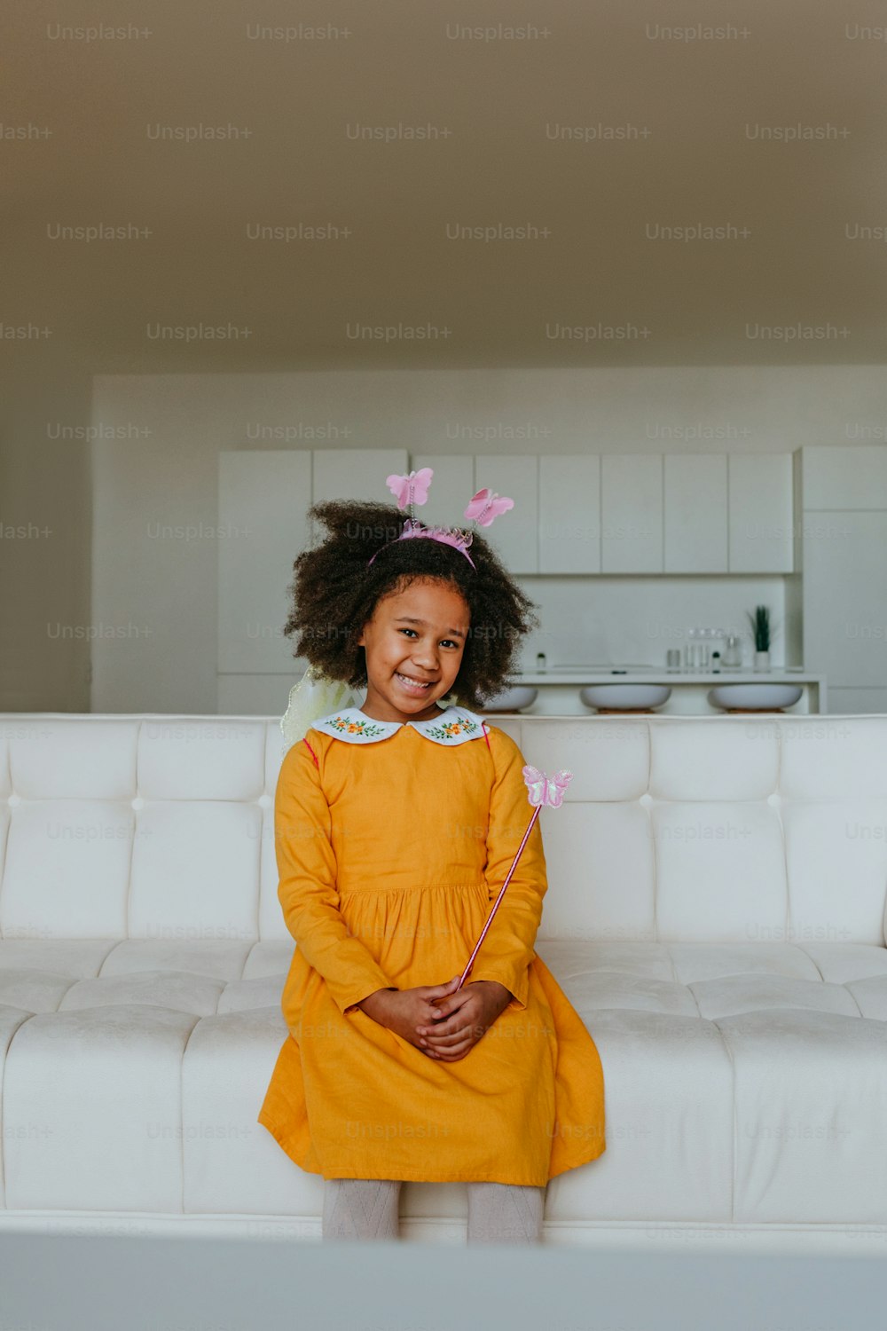 Retrato de uma menina bonita vestindo traje de borboleta em casa na sala de estar dentro de casa.