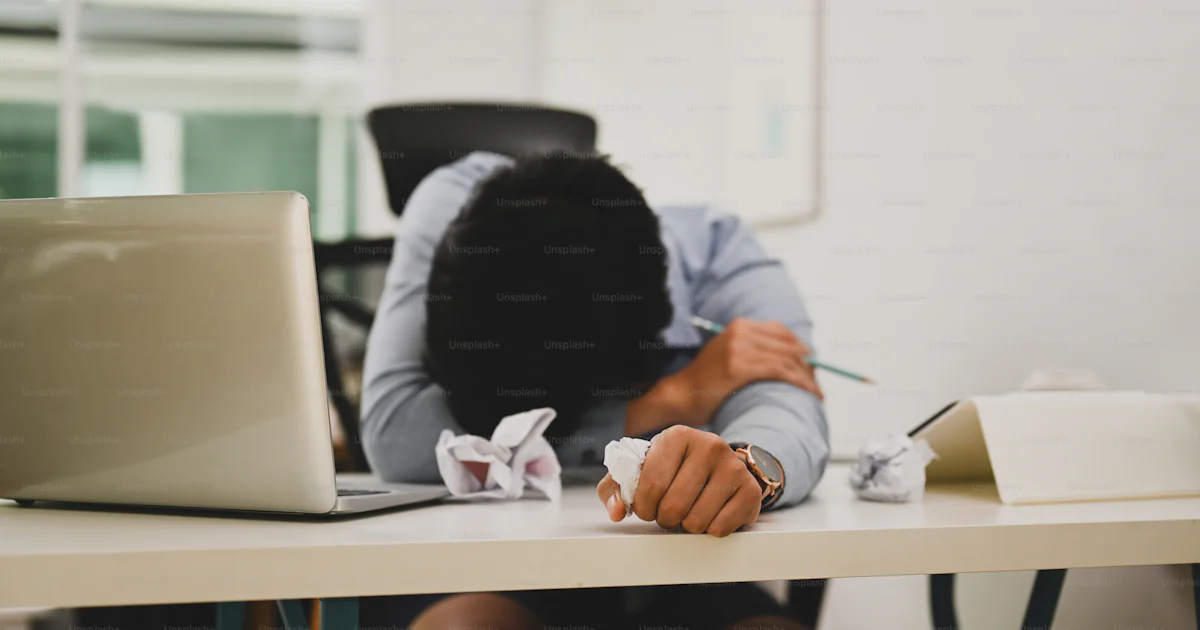 Overworked young man office worker fall asleep on his office desk ...