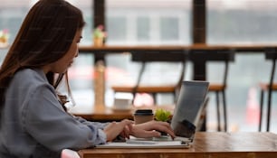 Femme ont étudié en ligne avec un enseignant, une jeune femme heureuse apprend une conférence regarder un webinaire écrire des notes regarder un ordinateur portable s’asseoir dans un café, l’éducation à distance
