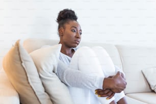 People, emotions, stress and health care concept - unhappy african american young woman touching her head and suffering from headache