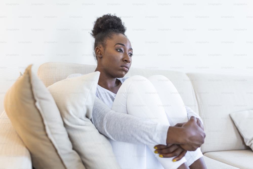 Personas, emociones, estrés y concepto de atención médica - mujer joven afroamericana infeliz que se toca la cabeza y sufre de dolor de cabeza