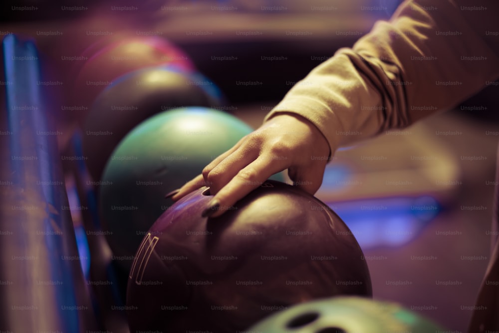 Woman taking bowling ball. Close up.