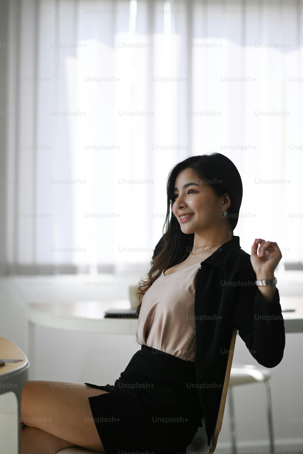Portrait of smiling businesswoman relaxing at her workplace and stretching her body.