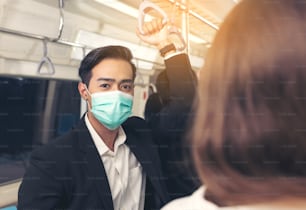 People on the train wear anti-virus masks and travel during rush hours. passengers inside the Sky Train with the masks on all people's faces.