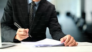Cropped shot of executives businessman signing or writing on documents.