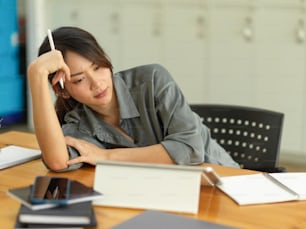 Close up view of female feeling upset while working with digital tablet and office supplies in office room