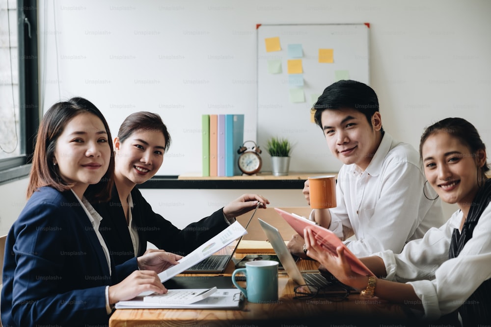Porträt eines jungen asiatischen Business-Teams, das in einem modernen Open-Space-Office-Startup zusammenarbeitet. Blick in die Kamera.