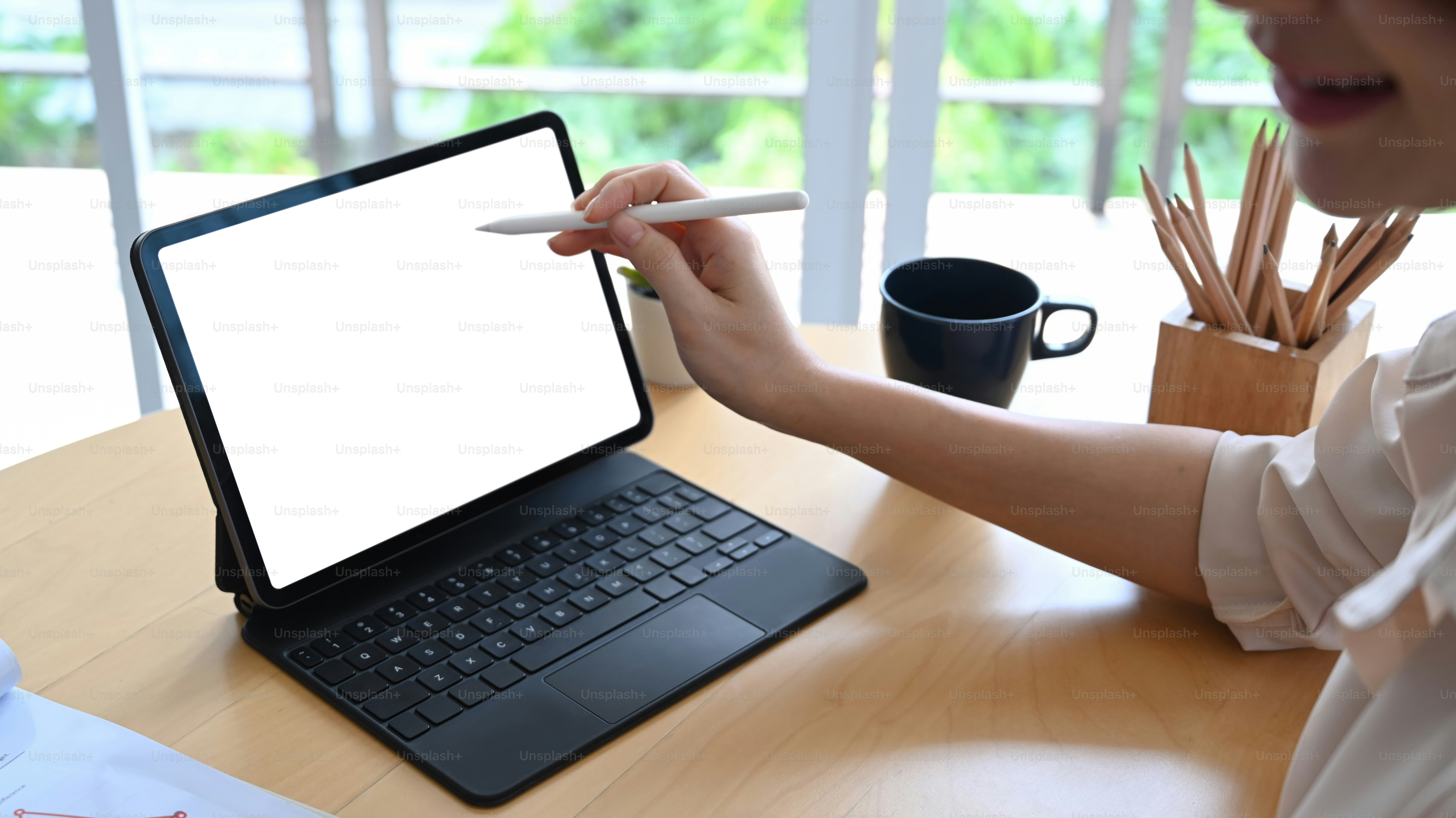 Foto recortada de una contadora que trabaja con una tableta de computadora y sostiene un lápiz óptico apuntando en la pantalla.