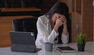 La mujer de negocios se estresa y tiene dolor de cabeza mientras tiene un problema