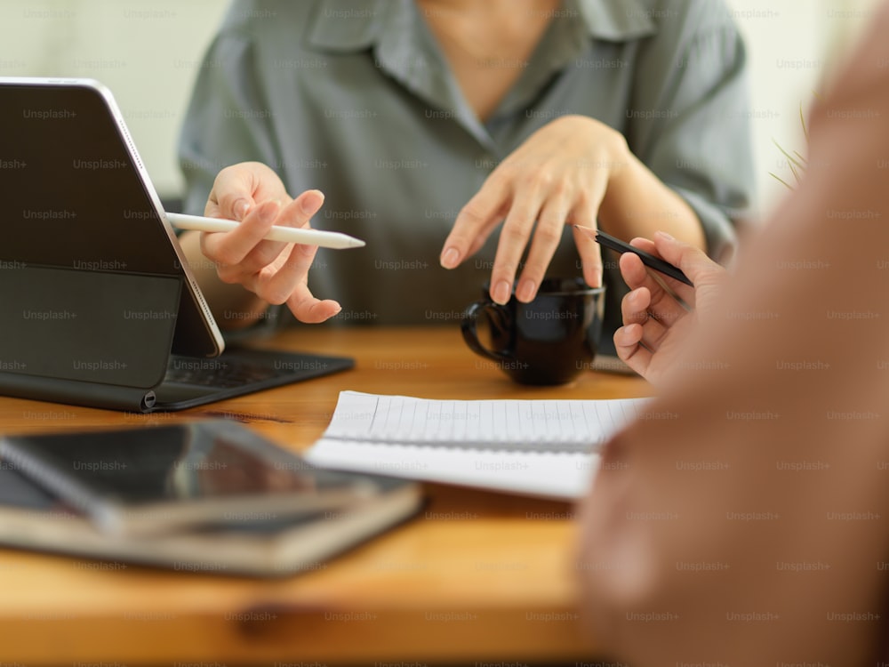 Close up view of female hands gesture while explaining her work to her colleague in meeting room