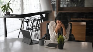 Frustrated businesswoman holding her head feeling upset about problem.