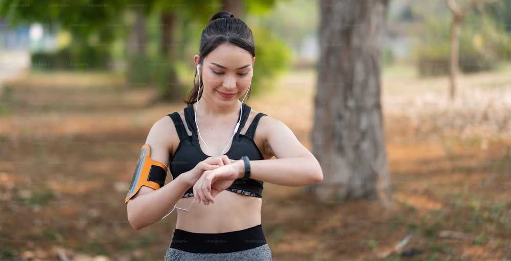 Entrenamiento de mujer joven al aire libre usando un estilo de vida saludable de reloj inteligente