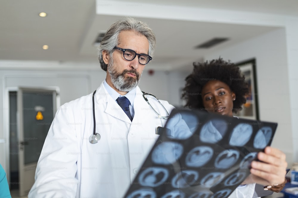 Equipo de profesionales de la salud que buscan radiografías de los pulmones del paciente. Médico y doctora mirando radiografías de pulmones en el hospital durante la pandemia de covid19