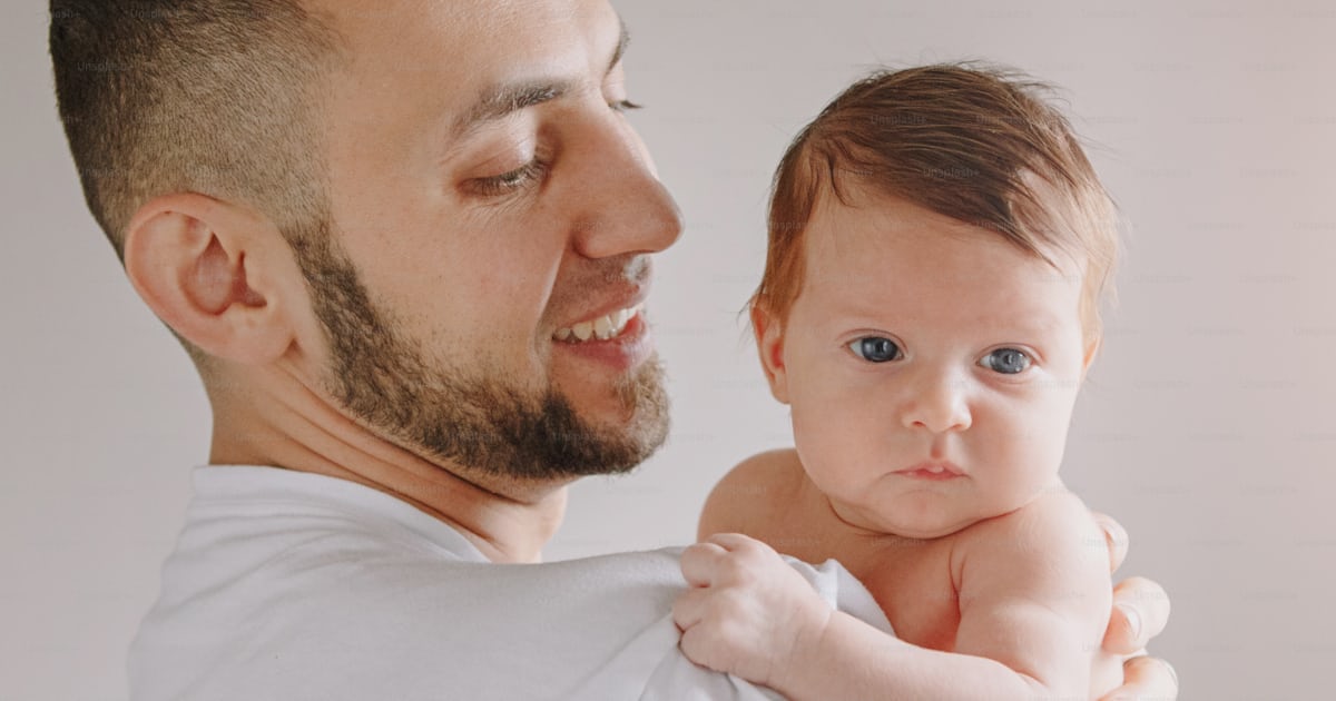 Caucasian father holding newborn baby. Man parent rocking child ...