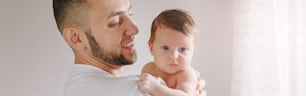 Caucasian father holding newborn baby. Man parent rocking child daughter son on hands. Authentic lifestyle candid moment. Young dad family life concept. Banner header for website.