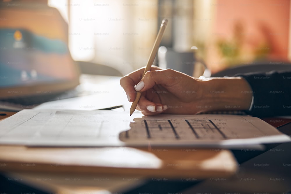 Cropped photo of an experienced draftswoman working at a technical drawing of a new building