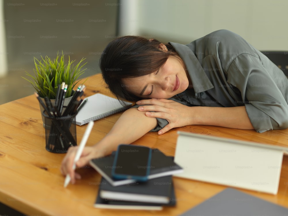 Portrait of female office worker take a nap when feeling tried while working in comfortable office room