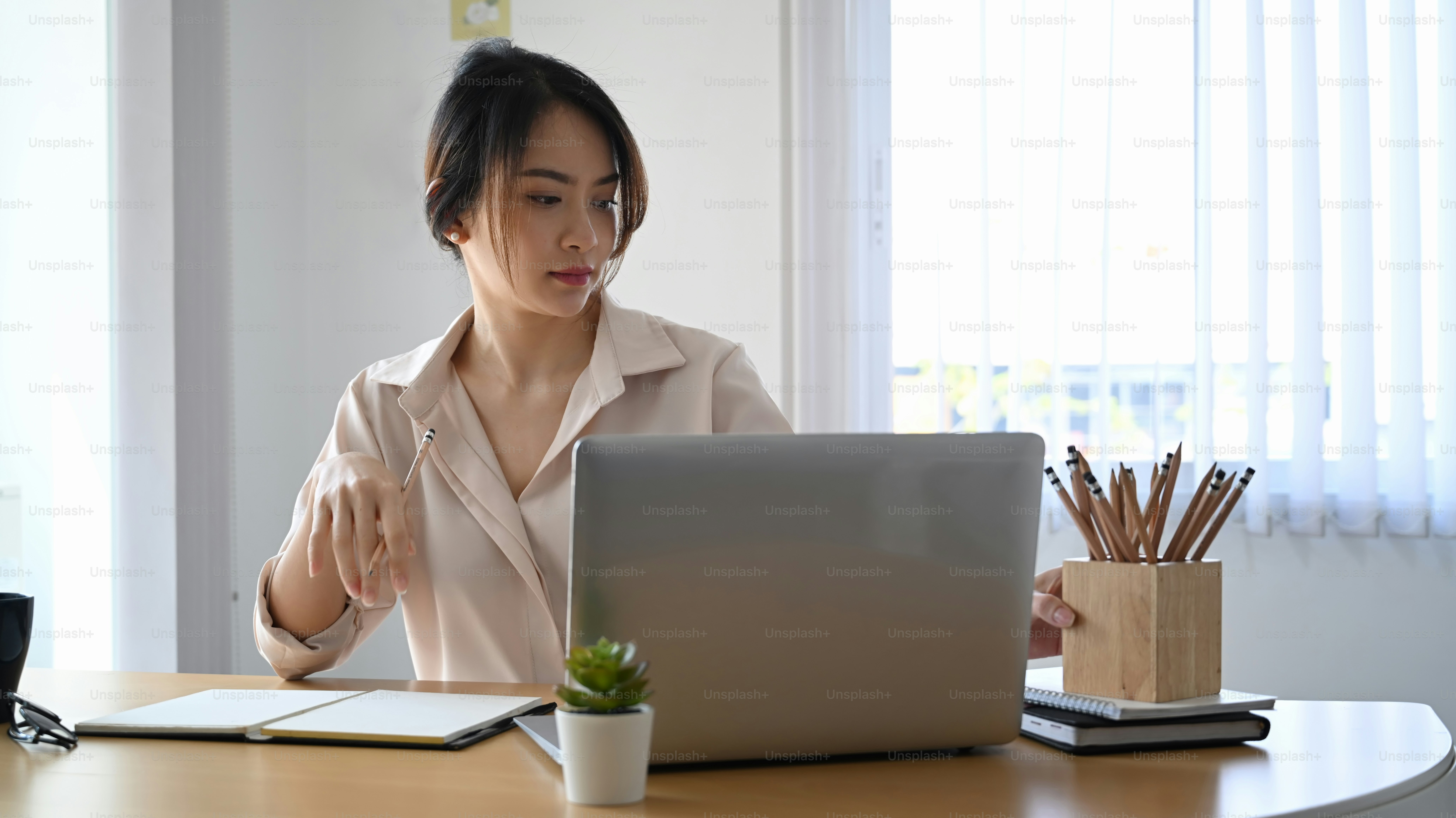 Confident young woman designer working with laptop computer at creative office