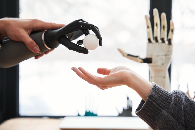 Person using a bionic prosthetic hand to pick up a tennis ball