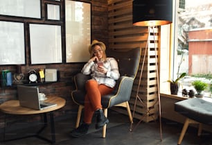 Junge Frau sitzt im Café und benutzt das Smartphone.