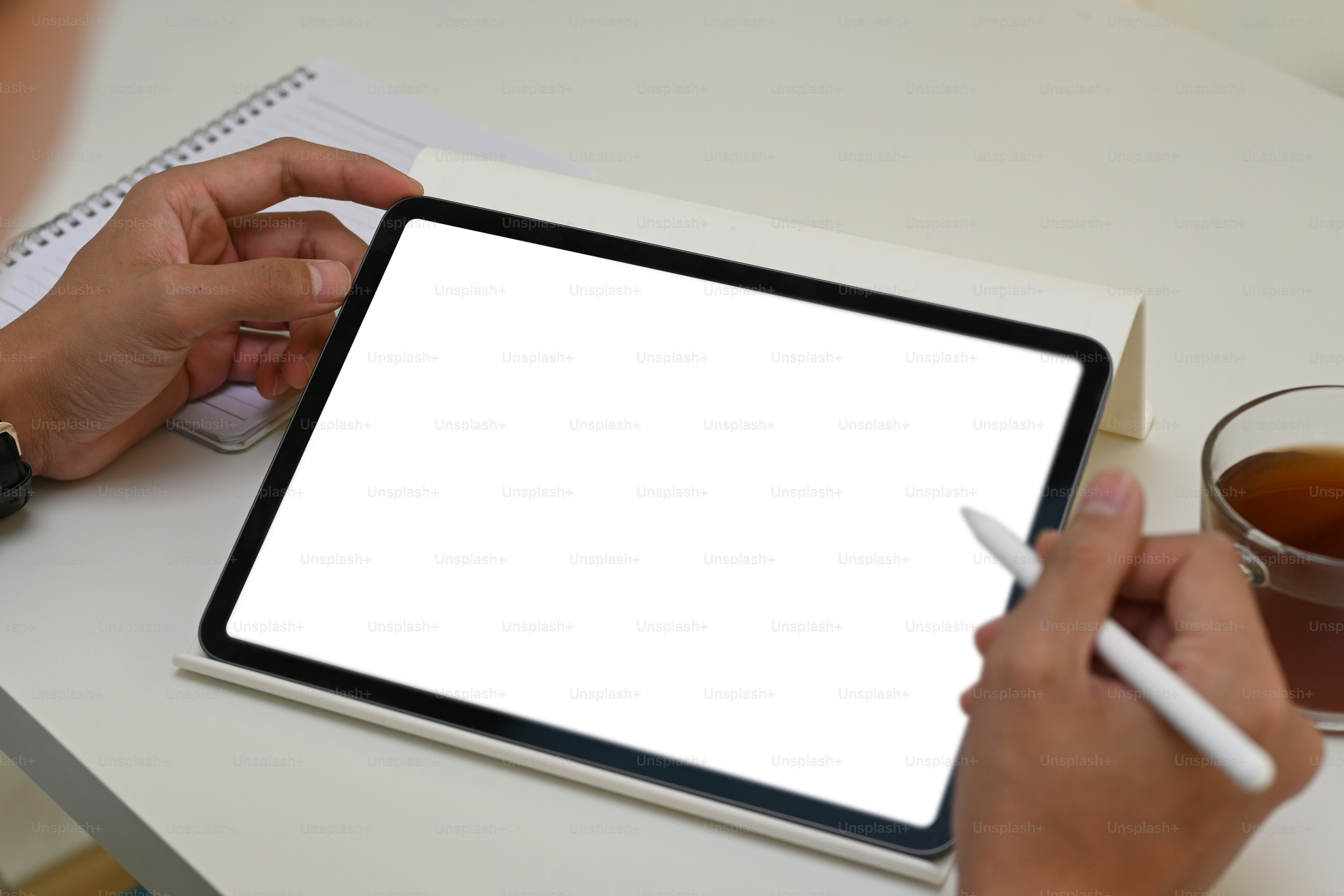 Close up vie of man holding digital tablet with blank screen and stylus pen.
