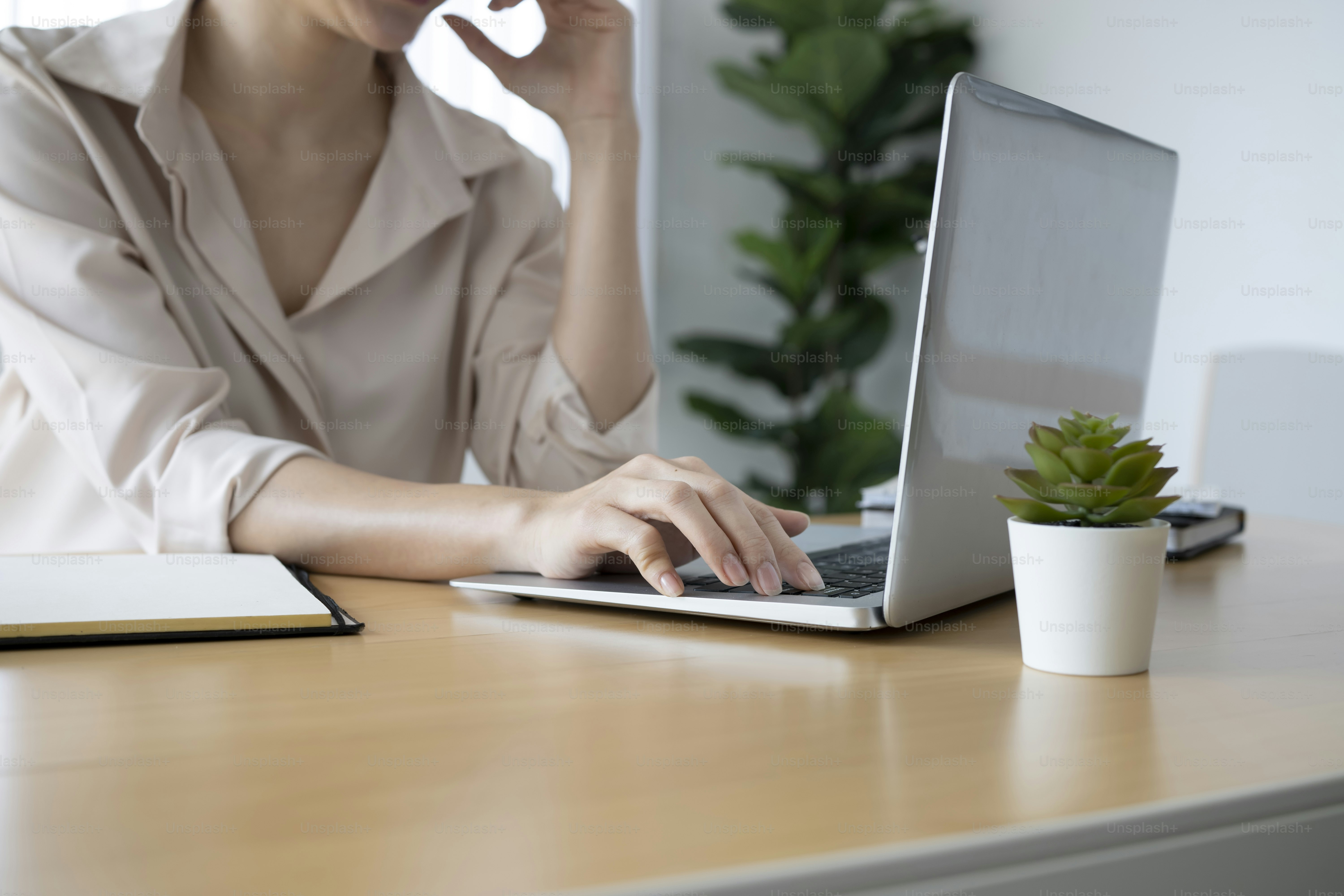Jeune femme comptable se concentre sur le travail sur un ordinateur portable sur un lieu de travail moderne.