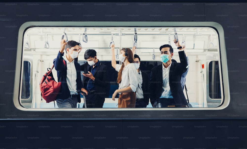 People on the train wear anti-virus masks and travel during rush hours. passengers inside the Sky Train with the masks on all people's faces.