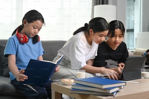 Three asian girl sitting on couch in living room and spend free time together at comfortable home.