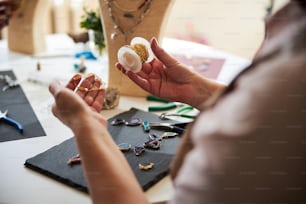 Cropped photo of an experienced craftswoman picking out the material for her new jewelry items