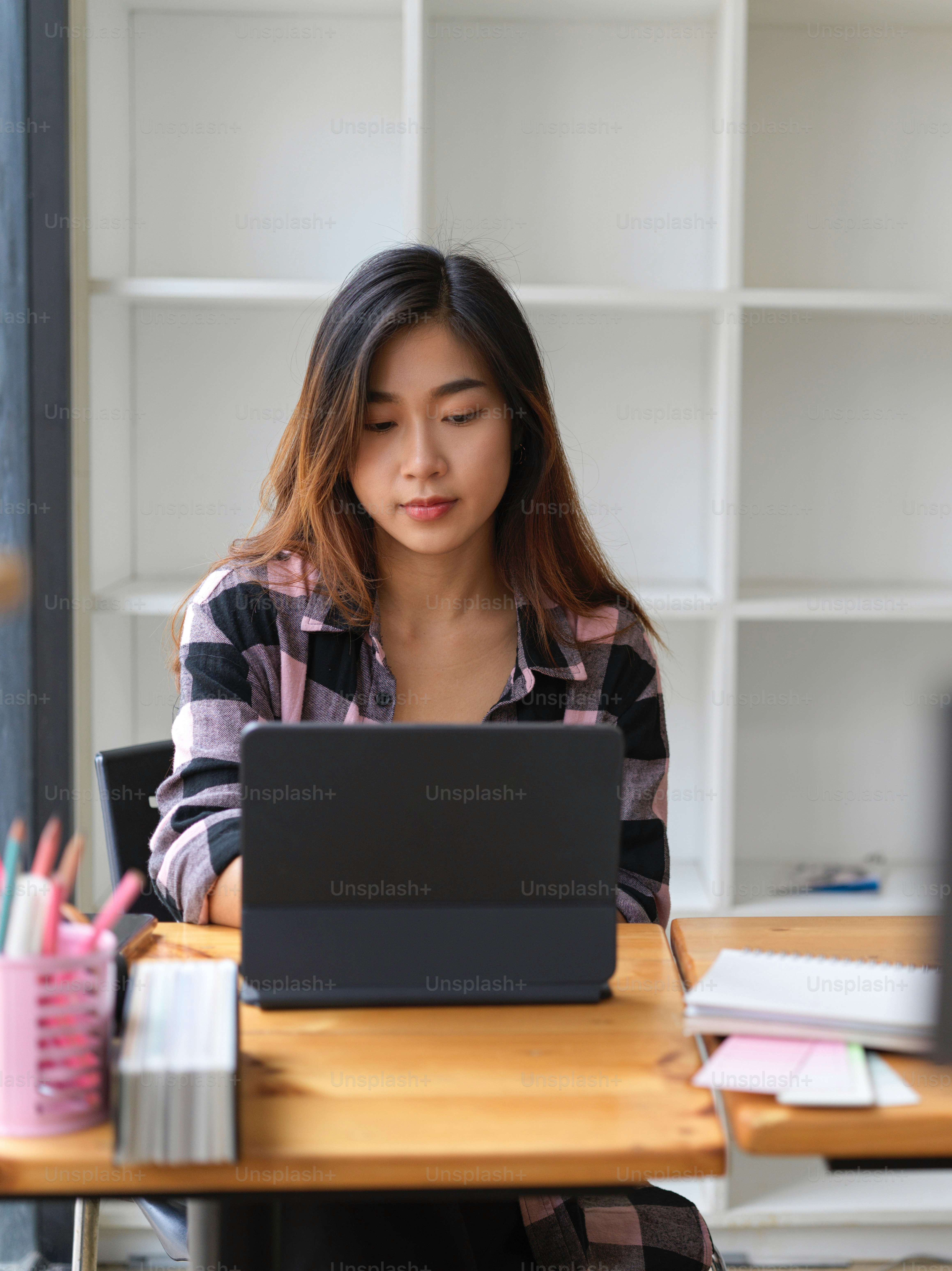Young beautiful female working in modern workspace with tablet