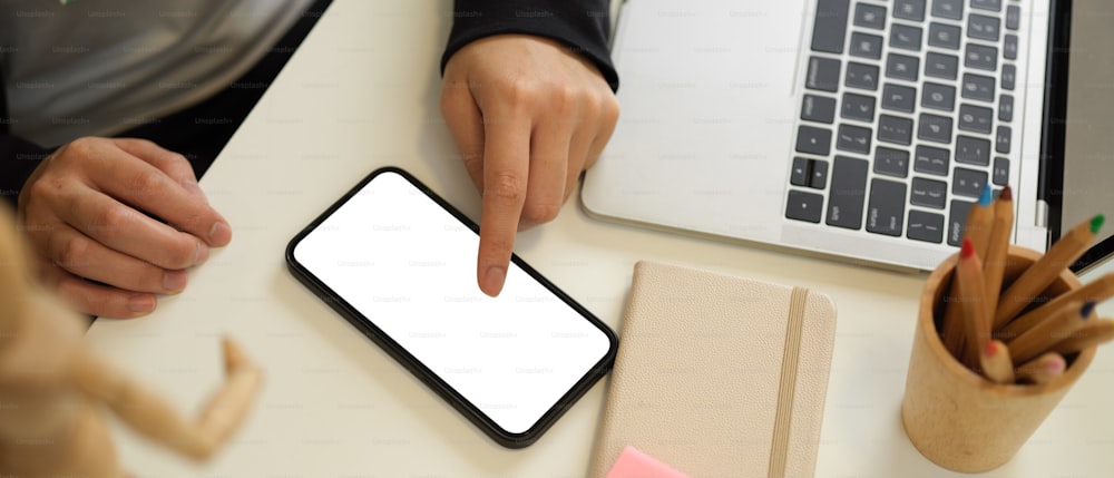 Top view of female touching on mock up smartphone screen while working in workplace, clipping path