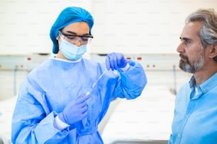 Atención médica con COVID-19, kit de recolección de hisopos de coronavirus, uso de guantes de máscara de traje protector PPE, tubo de ensayo para tomar una muestra de muestra de paciente OP NP, proceso de protocolo de prueba de ADN PCR