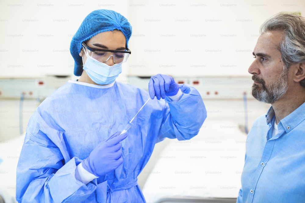 Soins de santé médicaux tenant COVID-19, kit de collecte d’écouvillon de coronavirus, portant des gants de masque de combinaison de protection EPI, tube à essai pour prélever un échantillon de patient OP NP, processus de protocole de test ADN PCR