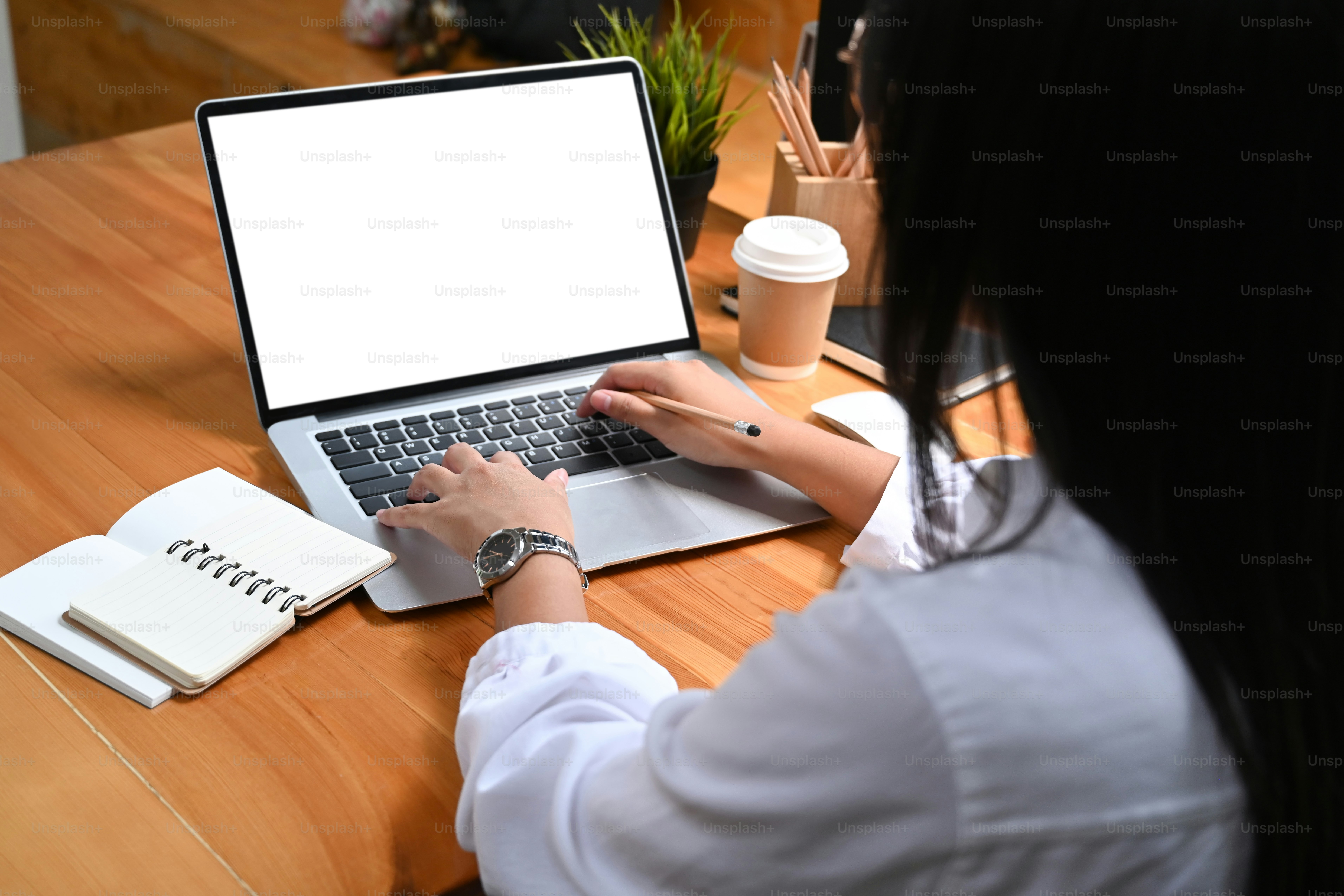 Vista sobre el hombro de la computadora portátil de trabajo de la mujer de negocios.