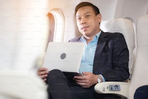 飛行機の中に座っているノートを持つビジネスマン