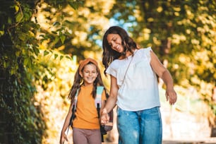 Sulla strada per andare a scuola. Bambina che cammina a scuola con sua madre.