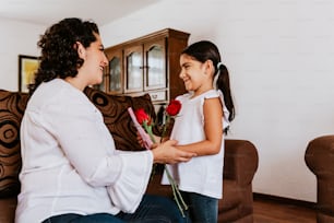 해피 어머니의 날, 멕시코 어린이 딸은 엄마를 축하하고 멕시코 시티의 집에서 꽃을 준다