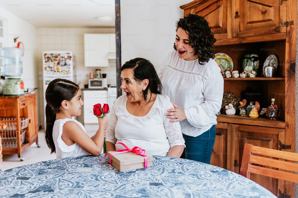 latin grandmother woman with daughter or grandchild celebrating birthday, 8 March International women holiday or Happy Mother's Day in Mexico city