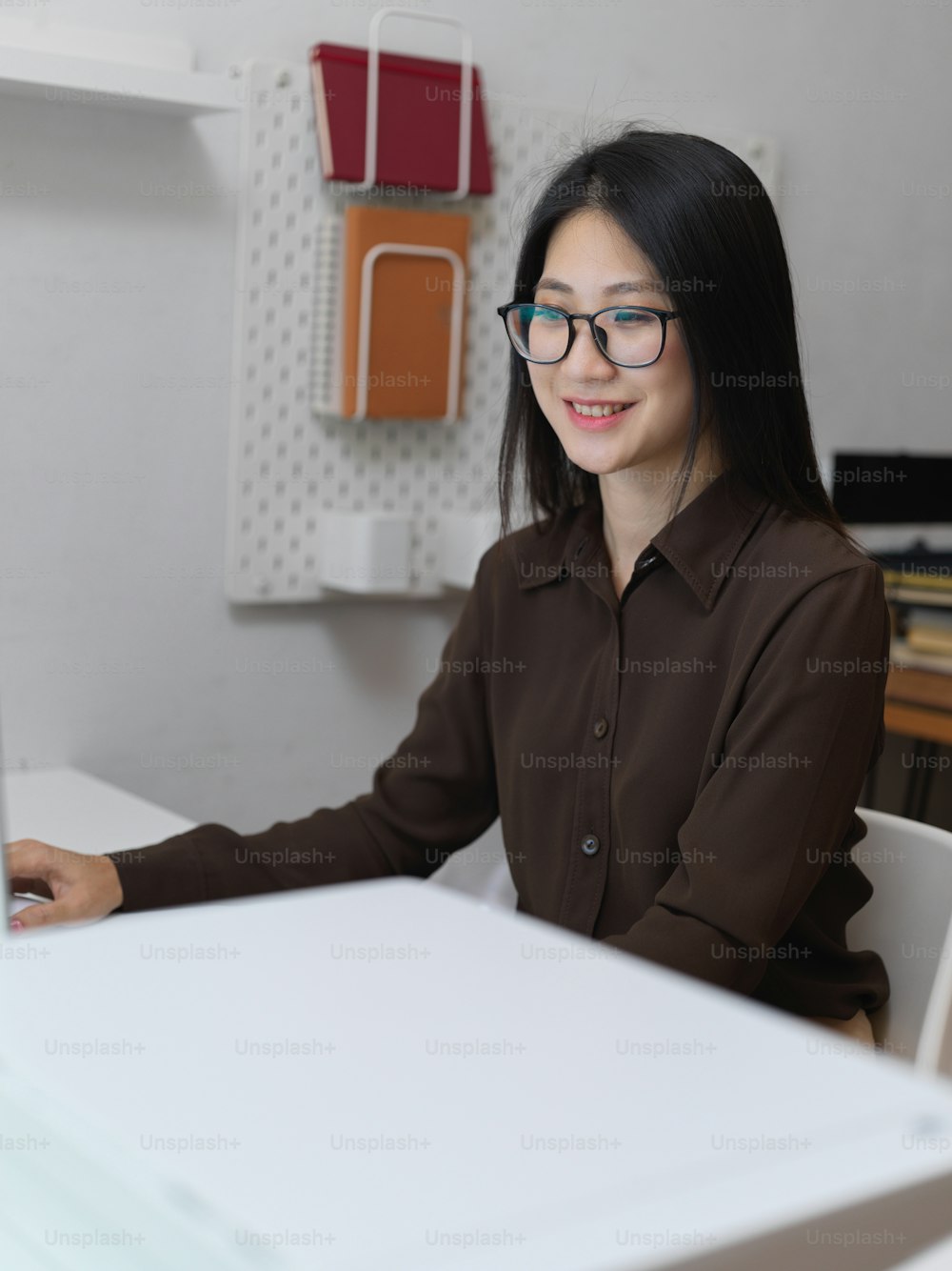 Portrait of friendly female office worker smiling while working in modern office room