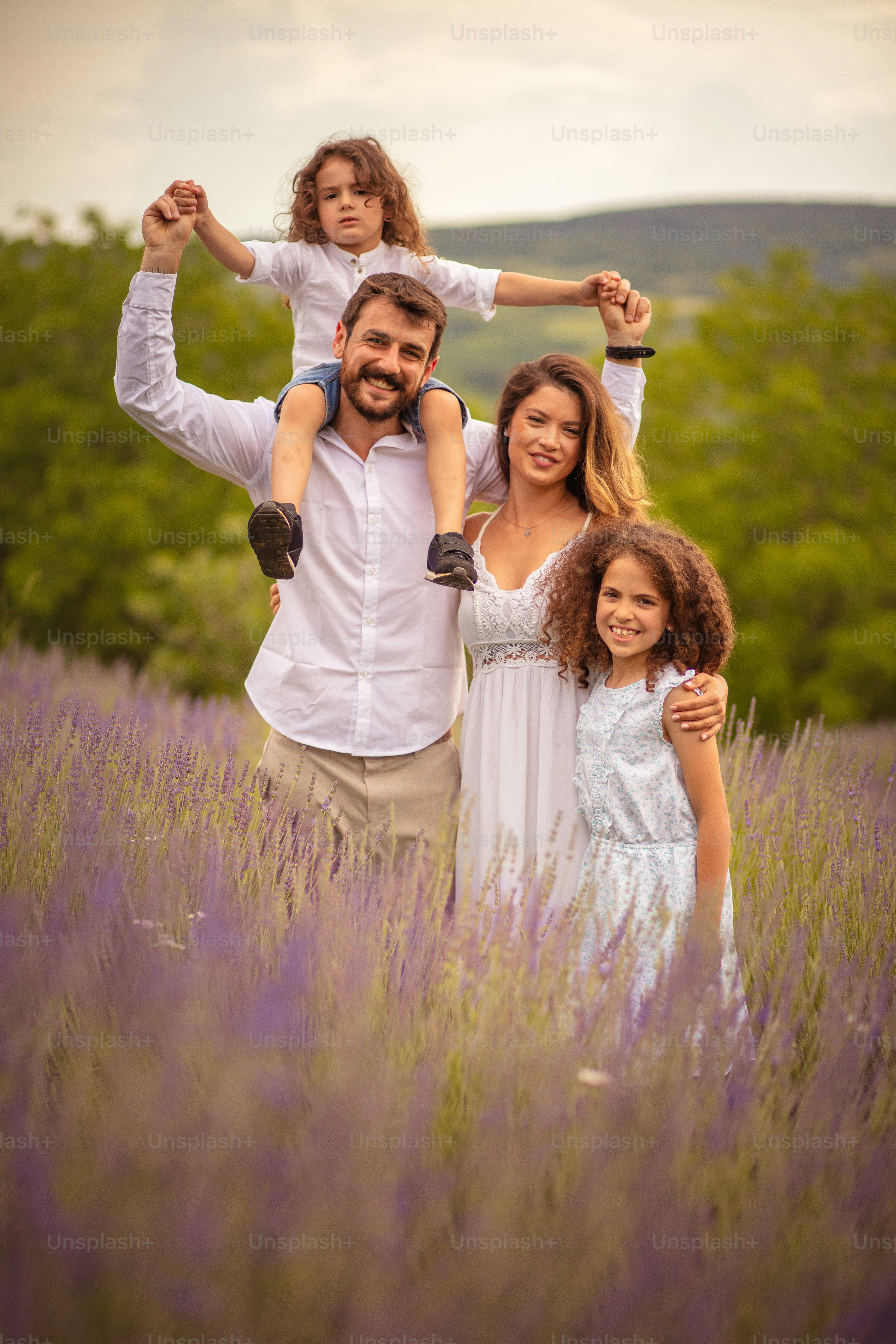 Keluarga di ladang lavender. Ayah menggendong bahu putranya.