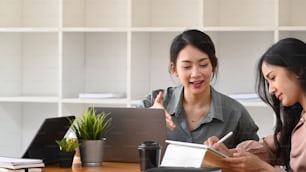 Cropped shot of two businesswoman working with digital tablet and sharing ideas in office.