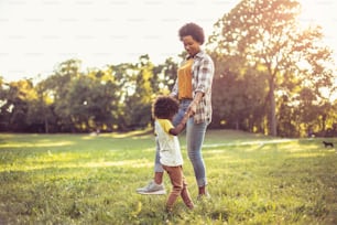 African American mother and daughter dancing in the park.