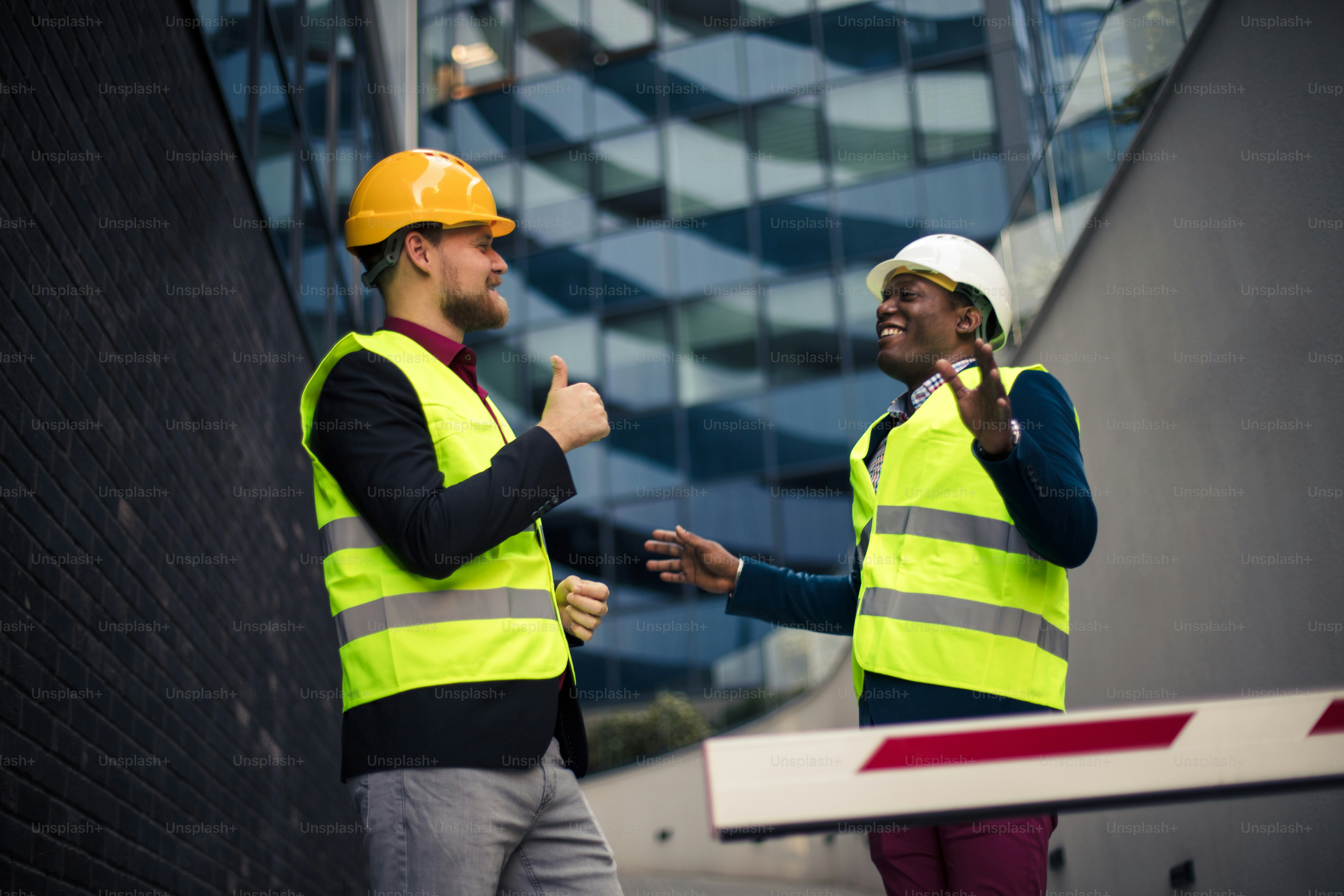 Construction workers talk at job site. Engineer discussing the structure of the building with architects colleague at construction site.
