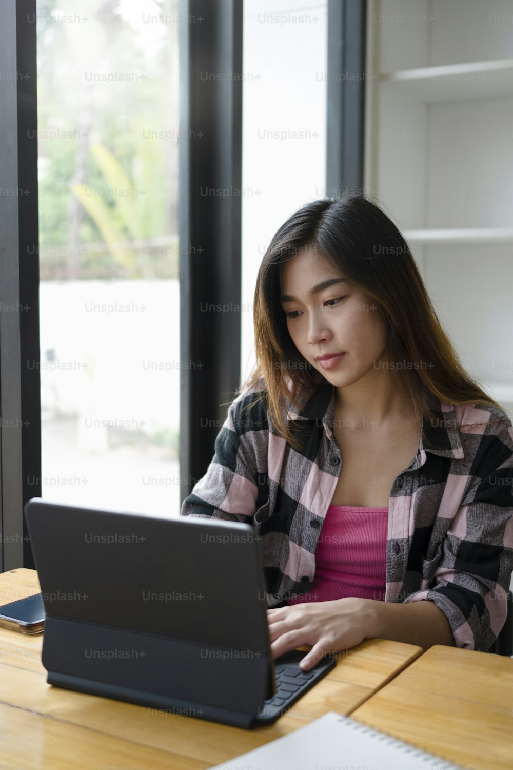 Portrait of casual young female freelancer working with computer tablet.