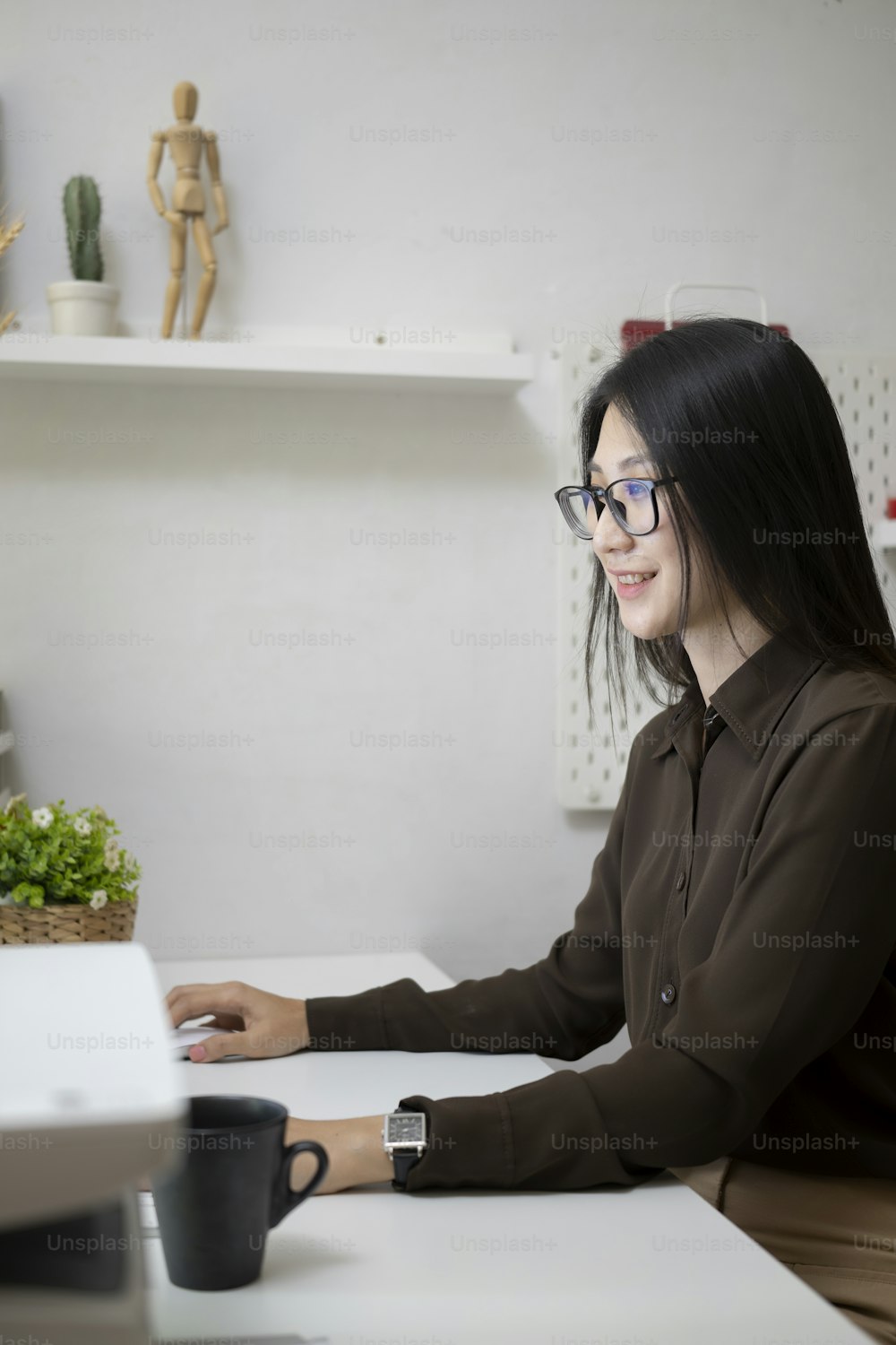 Side view of happy young woman smiling and working in office.
