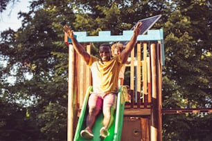 African American dad on toboggan with daughter.