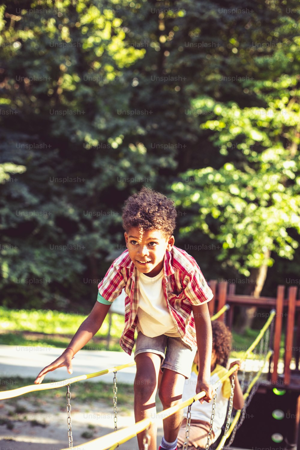 African American kids playing on bridge. Focus is on little boy.