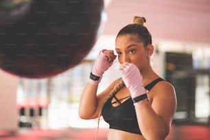 Woman boxer punching bag.