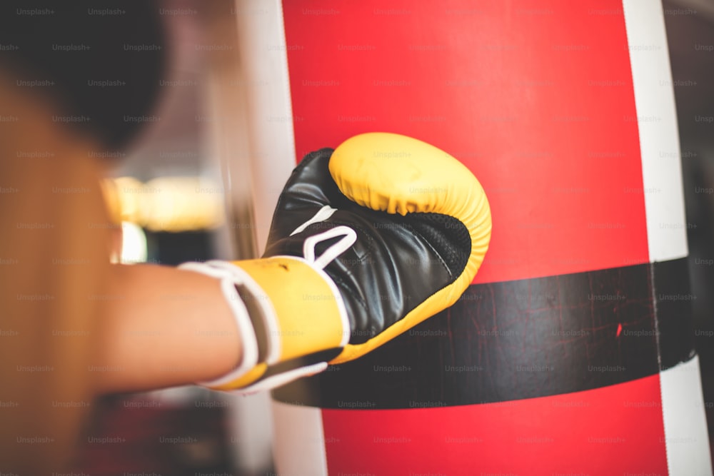 Woman boxer punching bag. Focus is on hand.